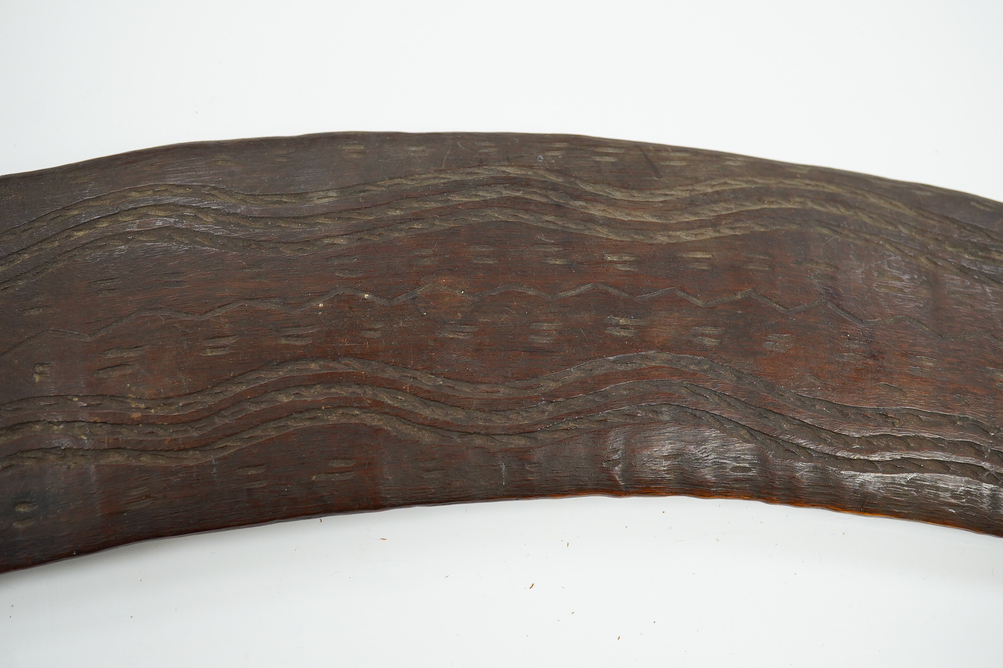 An Aboriginal boomerang, engraved to one side, 76cm wide. Condition - fair to good